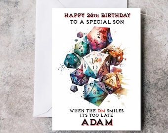 Puede incluir: Una tarjeta de cumpleaños con una ilustración de acuarela de dados coloridos, con el texto "HAPPY 28TH BIRTHDAY TO A SPECIAL SON" y "WHEN THE DM SMILES IT'S TOO LATE ADAM".