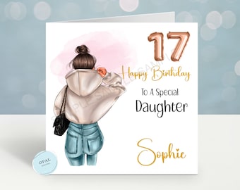 May include: A birthday card with a drawing of a woman wearing a white hoodie and blue jeans. The card has the number 17 in gold foil balloons and the text "Happy Birthday To A Special Daughter Sophie".