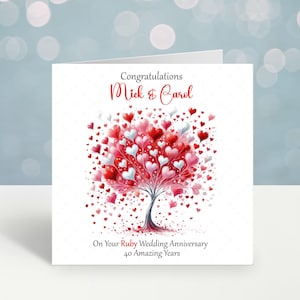 May include: A white card with a red and white heart tree design. The card says "Congratulations Mick & Carol On Your Ruby Wedding Anniversary 40 Amazing Years".