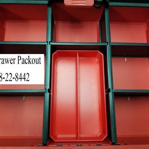 May include: Red and black 2-drawer Packout storage container with multiple compartments. The container has a central tray and several smaller compartments. The text "2 Drawer Packout" and "48-22-8442" are visible on a white label.