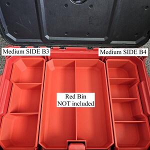 May include: A red plastic tool box organizer insert with multiple compartments. The insert features labels reading Medium SIDE B3, Medium SIDE B4, and Red Bin NOT included. The black lid of the tool box is open, revealing the red interior structure.