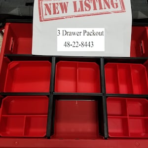 May include: A red and black 3-drawer Packout storage unit. The unit has a rectangular shape with three pull-out drawers. The drawers are red with black dividers. The text "NEW LISTING" is stamped on a white paper, along with the text "3 Drawer Packout 48-22-8443".