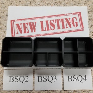 May include: Three black plastic storage boxes with dividers. The boxes are labeled BSQ2, BSQ3, and BSQ4.