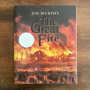 May include: The cover of a book titled "The Great Fire" by Jim Murphy. The cover features a painting of a city on fire with people running away from the flames.