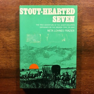 May include: A green book cover with the title "Stout-Hearted Seven" and the subtitle "The True Adventure of the Sager Children Orphaned on the Oregon Trail in 1844". The author's name, "Neta Lohnes Frazier", is printed below the subtitle. The cover features an illustration of a wagon train traveling across a grassy plain with a setting sun in the background.