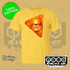May include: A yellow t-shirt with a graphic of a person's face on a tortilla chip. The text "100% Cotton" is on a green circle in the top left corner of the image. The text "Daisy" is in the bottom left corner of the image. The text "Good Nexus Merchandising" is in the bottom right corner of the image.