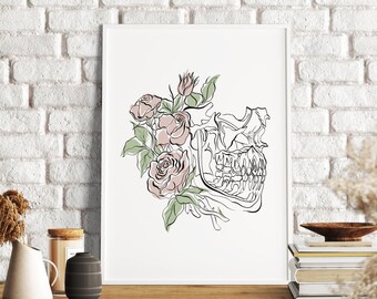 May include: A framed art print featuring a line drawing of a skull with roses. The artwork is in black and white with the roses in soft pink and green. The print is displayed on a wooden table against a white brick wall.