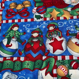 Può includere: Un tessuto a tema natalizio con sfondo blu. Il design presenta elfi, ornamenti, stelle e campane in rosso, verde, oro e bianco. Il tessuto è decorato con fiocchi di neve e strisce di bastoncini di zucchero.