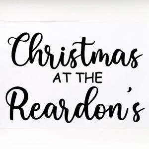 May include: A white sign with black calligraphy that reads "Christmas at the Reardon's".