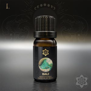 May include: A small, dark brown glass bottle with a black cap and label. The label has a gold design and the text "BALI AROMATHERAPY ESSENTIAL OIL BLEND".