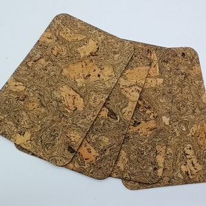 Könnte beinhalten: Vier braune Korkuntersetzer mit Marmormuster. Die Untersetzer sind aus Naturkork und haben einen rustikalen Look.
