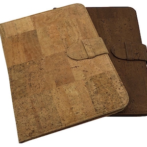 Może przedstawiać: Dwa skórzane teczki korkowe z klamrą. Teczka po lewej stronie jest jasnobrązowa, a teczka po prawej stronie jest ciemnobrązowa.