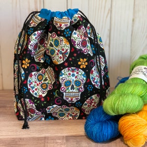 Middelgrote projecttas met trekkoord: *Sugar Skulls* met helderblauwe contraststof.