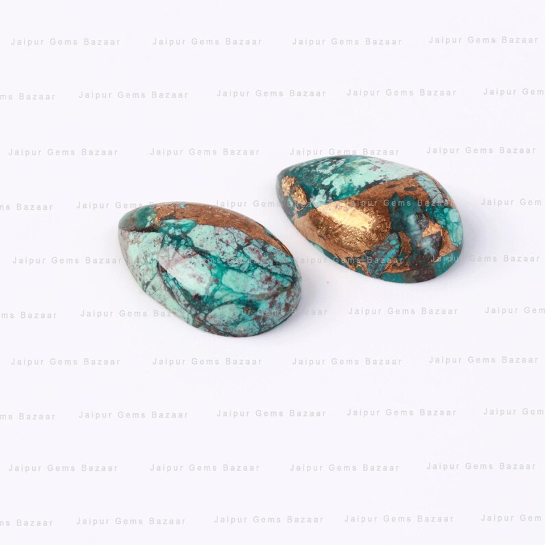 Puede incluir: Dos cabujones de turquesa en forma de l&aacute;grima con detalles dorados. Los cabujones son de color verde y azul moteado con motas de cobre y oro.