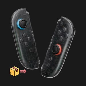 May include: Two transparent game controllers with black buttons and colored joysticks. One joystick is blue, and the other is red. The controllers have a clear casing, revealing internal components. The image includes a graphic with a box and the words "Mail In".