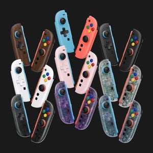 May include: A collection of gaming controllers in various colors and finishes, including solid wood grain, matte black, white, pastel pink, coral, and light blue, alongside several transparent models revealing internal components and colorful buttons.