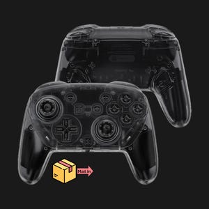 May include: Two transparent game controllers are displayed against a black background. The controllers are positioned one above the other, with the top one slightly out of focus. The bottom controller has a yellow box with the words "Mail In" next to it.