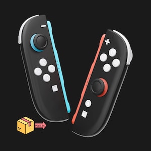 May include: Two black game controllers with white buttons and colored accents. One controller has a blue accent and joystick, the other has a red accent and joystick. The controllers are set against a black background.