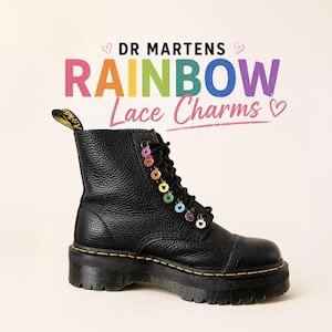Peut inclure: Botte noire Dr. Martens avec des breloques de lacets arc-en-ciel. La botte a une tige en cuir texturé, une semelle plateforme épaisse et des coutures jaunes. Le texte "DR MARTENS RAINBOW Lace Charms" est affiché au-dessus de la botte.