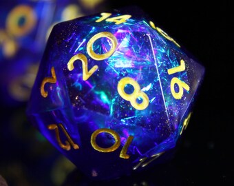 May include: A set of blue and gold dice with iridescent glitter embedded in the plastic. The dice are a D20, a D4, and a D6. The numbers on the dice are in gold.