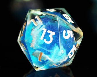 May include: A blue and white d20 dice with a cloudy design and white numbers. The dice is sitting on a black surface.