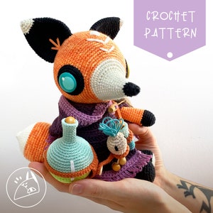 Peut inclure: Patron de crochet pour un jouet amigurumi de renard. Le renard est orange et blanc avec des yeux bleus et tient une petite bouteille et une fleur. Le renard porte une &eacute;charpe violette.