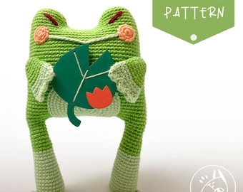 May include: Crochet pattern for a green frog holding a green leaf with a red flower. The pattern is titled "CROCHET PATTERN".