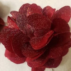This is a small maroon chiffon floral boutonniere with silver glitter shimmer added to give it a beautiful shine. The pin is silver