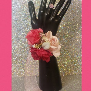 This is a corsage with light pink, hot pink, fuchsia artificial flowers. Includes matching silver tone pink bling ring