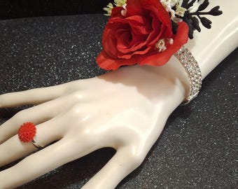 This is a beautiful corsage with red, black and white artificial flowers on an open back rhinestone wrist bracelet. Including matching ring.
