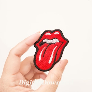 Puede incluir: Parche rojo bordado para planchar con la imagen de una lengua que sobresale con un contorno blanco y un borde negro.