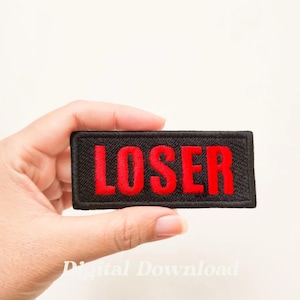 May include: A black fabric patch with red embroidered text that reads "LOSER".