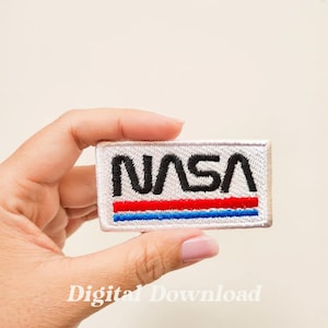 May include: White embroidered patch with the NASA logo in black lettering and red and blue stripes.