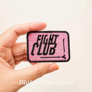 May include: Pink embroidered patch with the text "FIGHT CLUB" in black lettering.