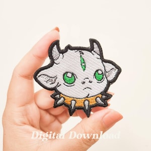 May include: Embroidered iron-on patch featuring a cartoon gray and white creature with green eyes and a yellow and black spiked collar.