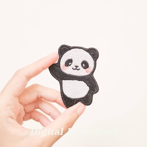 Puede incluir: Parche bordado de oso panda en blanco y negro, saludando con una expresión sonriente. El panda tiene mejillas rosadas y es sostenido por una mano sobre un fondo blanco. Ideal para añadir a ropa o accesorios. Un artículo decorativo.