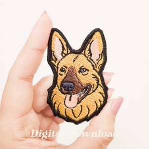 Può includere: Toppa ricamata raffigurante la testa di un pastore tedesco. La toppa ha un bordo nero, con dettagli beige, marroni e rosa. Il cane sorride con la lingua di fuori. Il testo "Digital Download" è in basso.