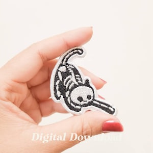 May include: Embroidered patch featuring a black and white skeleton cat in a playful pose. The patch has a detailed design with visible rib cage and skull. The text "Digital Download" is at the bottom.