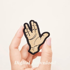May include: A beige embroidered patch of a hand making the Vulcan salute, a popular gesture from the Star Trek franchise. The patch is outlined in black thread.