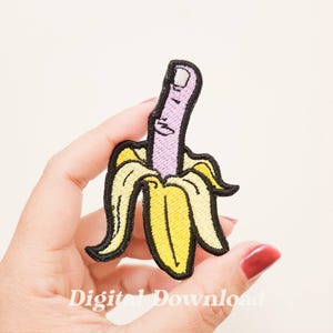 May include: Embroidered patch depicting a banana with a finger as the peel. The finger is purple with a white nail, and the banana peel is yellow with black outlines. The text "Digital Download" is at the bottom.