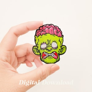 May include: Embroidered patch featuring a green zombie head with exposed pink brain, white eyes, and a red mouth. The patch has a black outline and is held in a hand. Text at the bottom reads "Digital Download".