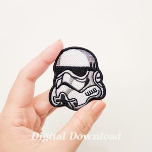 May include: A white and black embroidered patch of a Star Wars Stormtrooper helmet.