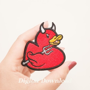 Może przedstawiać: Haftowana naszywka z czerwoną kaczką diabła z czarnym konturem, białymi rogami i żółtym dziobem. Kaczka trzyma srebrny trójząb. Tekst "Digital Download" znajduje się na dole.