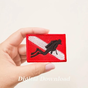 May include: A red and white scuba diver flag patch with a black silhouette of a diver. The patch is embroidered and has a white border.