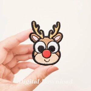 May include: Embroidered iron-on patch of a cartoon reindeer with big eyes, a red nose, and a brown and tan face.