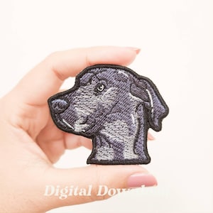 Può includere: Toppa ricamata raffigurante la testa di un cane in tonalità di grigio e nero. La toppa ha un design dettagliato con cuciture visibili e un bordo nero. Il testo "Digital Download" è visibile in basso.