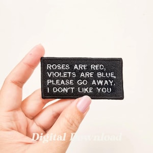 May include: Black embroidered patch with white text that reads "Roses are red, Violets are blue, Please go away. I don't like you."