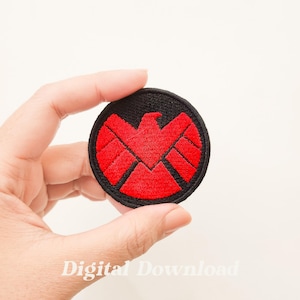 Pode incluir: Um patch redondo bordado em preto com um emblema de águia vermelha. O patch tem uma borda preta e um design vermelho no centro. O texto "Digital Download" está na parte inferior.