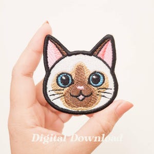 May include: Embroidered iron-on patch of a Siamese cat with blue eyes, brown nose, and pink ears. The cat is smiling with its tongue sticking out.