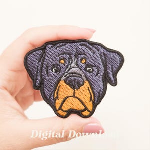 Puede incluir: Parche bordado con la cabeza de un perro Rottweiler. El parche tiene una combinación de colores negro y naranja, con detalles de la cara. El texto "Digital Download" es visible en la parte inferior.